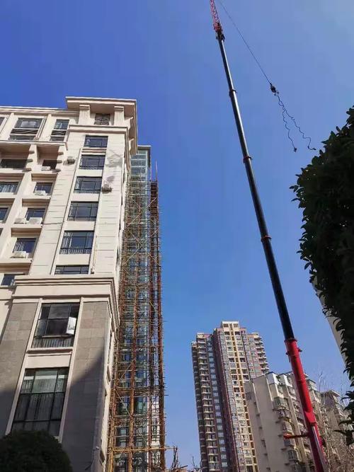红谷滩立面改造项目城管大楼工程正进行观光电梯外架拆除作业